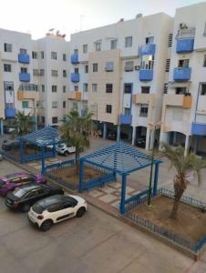 un parking avec des voitures garées devant un bâtiment dans l'établissement Appartement Agadir, à Agadir