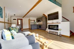 a living room with a couch and a fireplace at The Owl Barn Wiltshire - Flint in Swindon