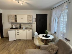 a living room with a table and a kitchen at Apartamenty Ostryga Łeba in Łeba