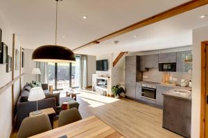 a living room with a couch and a kitchen at The Owl Barn Wiltshire - Slate in Swindon