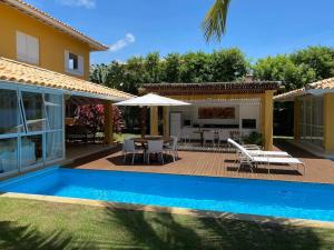 een huis met een zwembad naast een huis bij Quintas de Sauipe - modernes Haus im Condomínio mit Service in Mata de Sao Joao