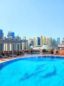 a large swimming pool on top of a building with a city skyline at Luxury 1 Bedroom With Sea View in Dubai