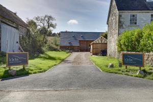 a driveway leading to a barn with signs in front of it at The Owl Barn Wiltshire - Slate in Swindon