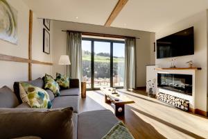 a living room with a couch and a fireplace at The Owl Barn Wiltshire - Slate in Swindon