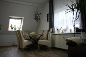 a dining room with a table and chairs and a window at Ferien Oase am BER in Schönefeld