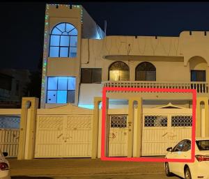 ein weißes Auto, das nachts vor einem Gebäude parkt in der Unterkunft Bzxmax Guest House in al-Ain