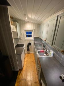 a small kitchen with white cabinets and a wooden floor at Gilleråsvägen 13 C in Sälen