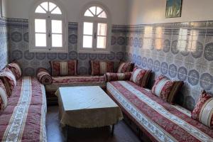 - un salon avec des canapés, une table et des fenêtres dans l'établissement Appartement spacieux, à Casablanca