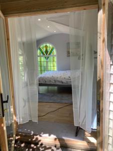 a bedroom with a bed through a glass door at Honey Bee Cabin in Llandysul