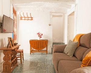 - un salon avec un canapé et une table dans l'établissement la casita del pueblo PET friendly granada, à Acebuches