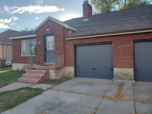 uma casa de tijolos vermelhos com duas portas de garagem em Utah's Great Outdoors. 2 Bd/1 Ba + kitchen em Salt Lake City