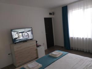 una camera con TV su un comò con un letto di Runk House a Câmpulung Moldovenesc