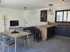 a kitchen and living room with a table and chairs at Villa Montélimar in Montélimar