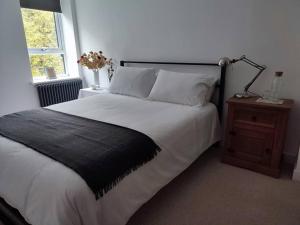 a bedroom with a large bed and a lamp on a night stand at Brook Terrace in Luddenden Foot