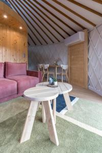 sala de estar con sofá rosa y mesa en GÓRSKI GLAMPING - Całoroczne jurty z widokiem, en Tylmanowa