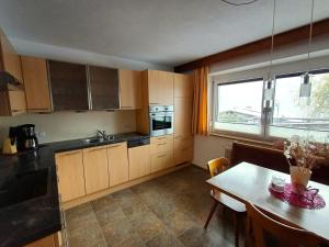 una pequeña cocina con mesa y ventana en Apartment Marina en Wenns