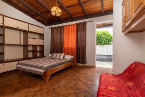 ein Schlafzimmer mit einem Bett und einem roten Sofa in der Unterkunft Apetahi Lodge in Paea