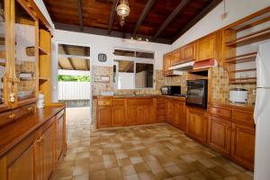 a large kitchen with wooden cabinets and appliances at Apetahi Lodge in Paea