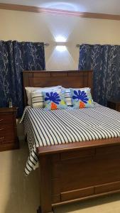 a bed with blue and white sheets and pillows at Victory Luxury Apartments in Montego Bay