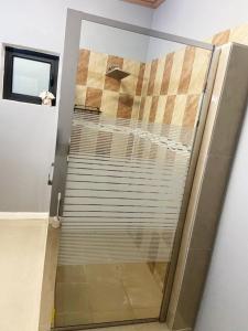 a glass door to a bathroom with a stair case at Victory Luxury Apartments in Montego Bay