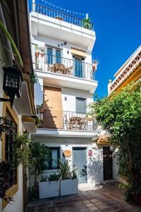 a tall white building with a balcony at Bonita Casa CUCA in Marbella