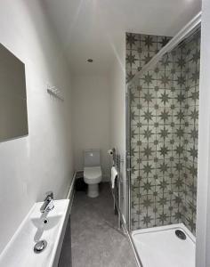 La salle de bains est pourvue de toilettes, d'un lavabo et d'une douche. dans l'établissement Stylish House with parking in Caversham nr Reading, by Sauvignon Stays, à Caversham