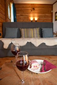 2 Gläser Wein auf einem Tisch mit einem Bett in der Unterkunft Hotel Rajska Vrata in Jahorina