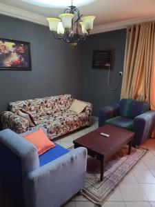 a living room with two couches and a table at Eunique Residence in Port Harcourt