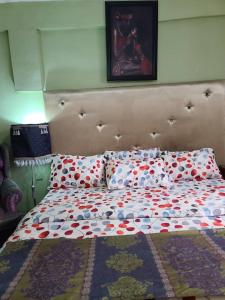 a bed with a headboard and two pillows on it at Eunique Residence in Port Harcourt