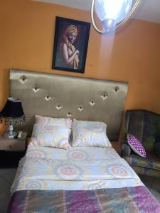 1 cama en un dormitorio con una foto en la pared en Eunique Residence, en Port Harcourt
