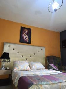 a bedroom with a bed with a picture on the wall at Eunique Residence in Port Harcourt