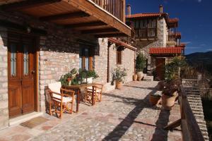 a patio with a table and chairs and a building at Cozy Mountain Cabin in Karpenision