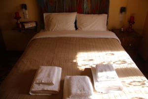 ein Bett mit Handtüchern drauf, auf dem die Sonne scheint in der Unterkunft Cozy Mountain Cabin in Karpenisi