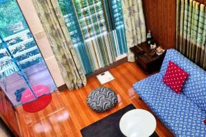 a living room with a blue couch and a table at Cozy TinyHouse near SM & Bagasbas Beach w/parking in Daet