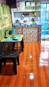 a kitchen with a table and a table and a kitchen with a counter at Cozy TinyHouse near SM & Bagasbas Beach w/parking in Daet