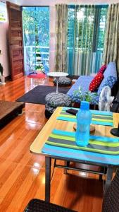 sala de estar con mesa y sofá en Cozy TinyHouse near SM & Bagasbas Beach w/parking, en Daet
