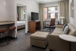 une chambre d'hôtel avec un canapé, un lit et une télévision dans l'établissement Residence Inn by Marriott Portland Downtown/Pearl District, à Portland