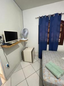 Habitación con cama y escritorio con ordenador. en Renan suítes, en Arraial do Cabo