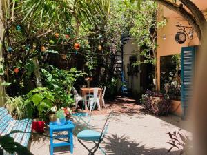un patio con sillas, mesa y árboles en Lina's Tango Guesthouse en Buenos Aires