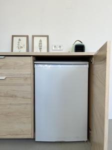 a kitchen with a white refrigerator under a counter at Maria Studio in Cascais
