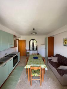 Il comprend une cuisine et un salon avec une table et un canapé. dans l'établissement Appartamento 1 lato mare, à Trappeto
