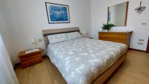 sypialnia z łóżkiem, komodą i lustrem w obiekcie Castagnole Apartment w mieście Castagnole