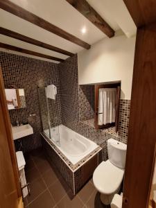 uma casa de banho com uma banheira, um WC e um lavatório. em APARTAMENTOS PALACION DE SANTILLANA em Santillana del Mar