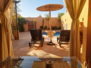 un patio con due sedie e un tavolo con ombrellone di Villa brek a Marrakech