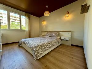 1 dormitorio con 1 cama y 2 ventanas en Appartement cosy - 3 chambres - 700m centre Ecully, en Écully