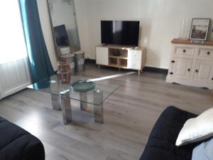 a living room with a glass table and a tv at Verdun 228 Insolite in Chambéry