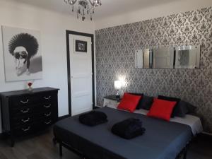 1 dormitorio con cama azul y almohadas rojas en Verdun 228 Insolite, en Chambéry