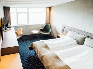 a hotel room with a bed and a chair at Hotel Føroyar in Tórshavn