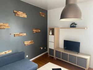 a living room with a blue couch and a tv at Appartement Leforest Centre 50m2 in Leforest