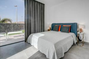 a bedroom with a bed with a blue headboard at Villa Izabele - private heated pool with amazing terrace in Callao Salvaje +22 photos